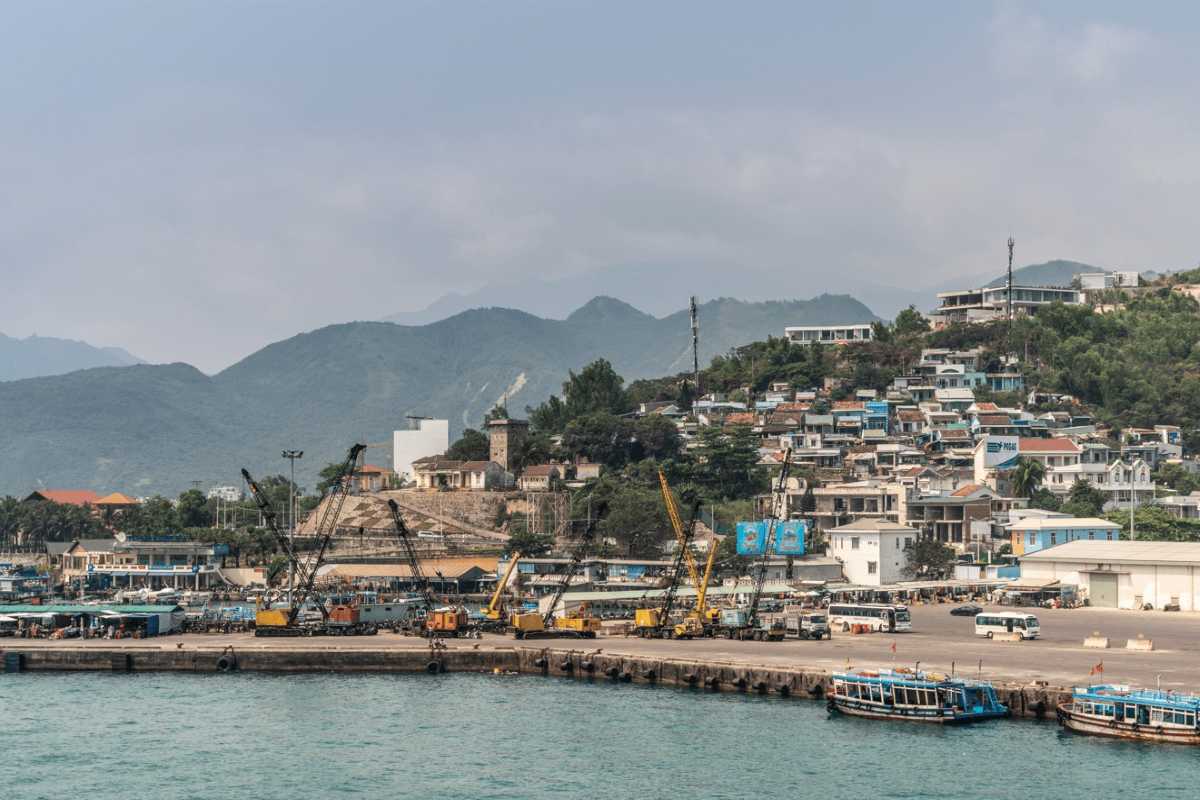 Beachfront resort area at Tuan Chau Harbor Halong with orange roofs and lush greenery along the coastline.