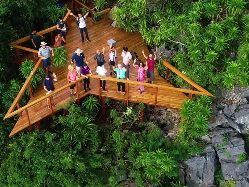 Viewpoint at Soi Sim Island with wooden deck and tourists Tourists standing at the wooden viewpoint deck at Soi Sim Island overlooking the lush landscape.