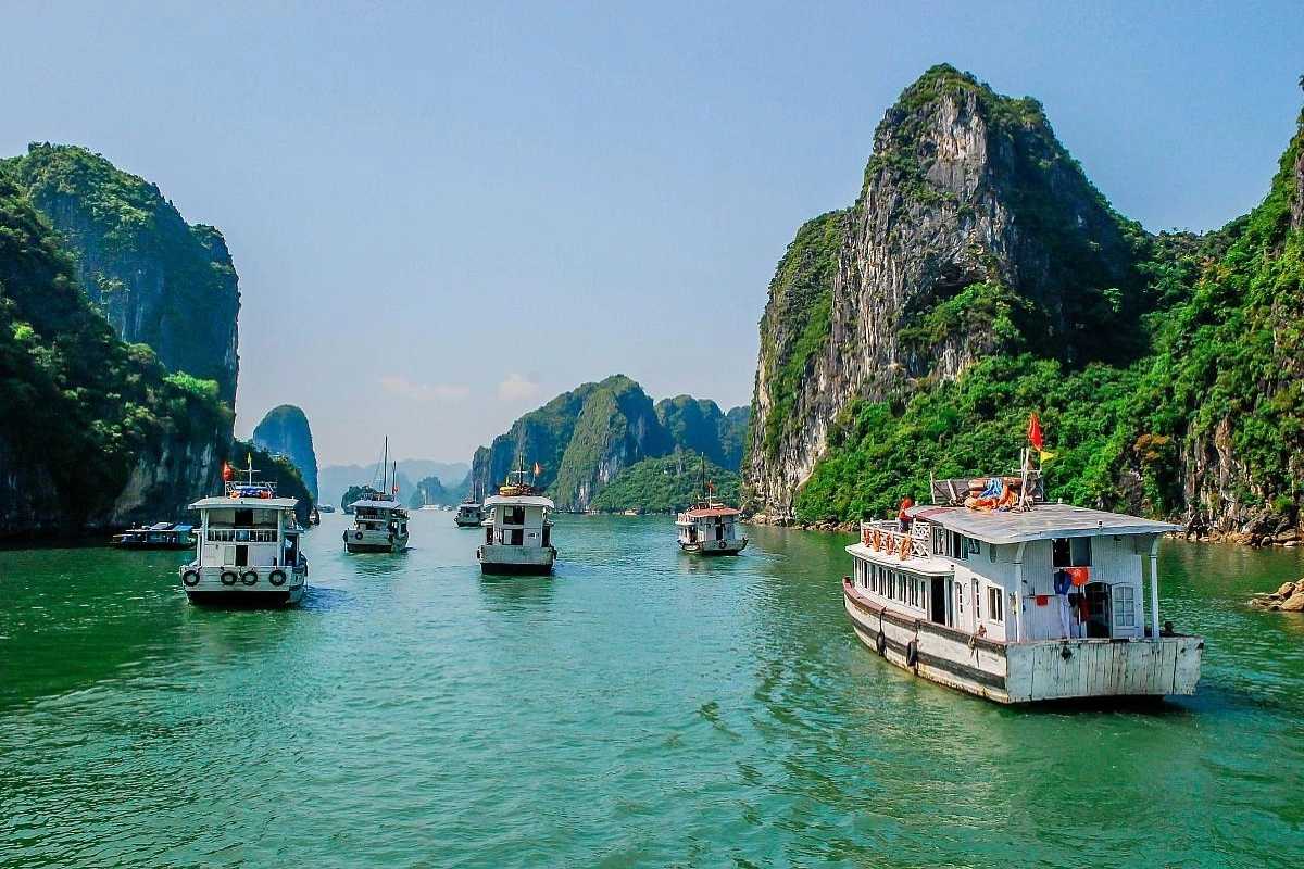 View of Virgin Cave Halong Bay entrance with towering limestone cliffs and natural rock