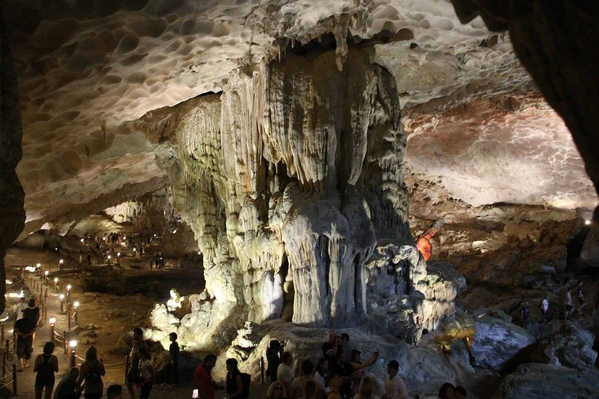 Large illuminated rock formations inside Virgin Cave Halong Bay glowing with warm light