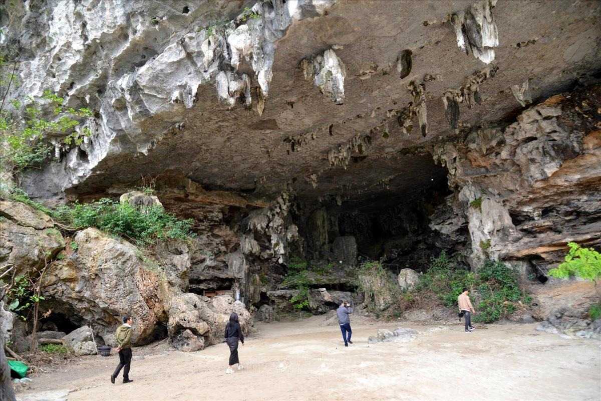 Tourists exploring the cave entrance and surroundings of Virgin Cave Halong Bay