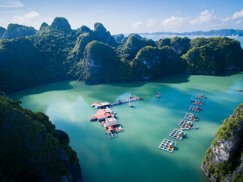 Vung Vieng Fishing Village from Above Aerial view of Vung Vieng Fishing Village, showcasing its floating homes and boats amidst the pristine waters of Bai Tu Long Bay.