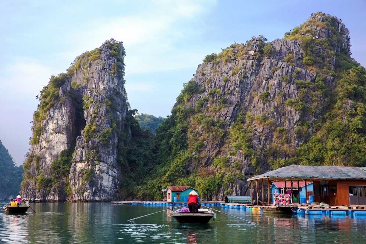 Woman performing daily tasks on floating home deck at Vung Vieng Fishing Village on Halong Bay