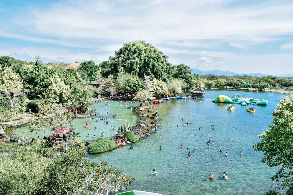 Floating games and pool fun at Waterland Large natural pool with inflatable games and visitors enjoying water play at Waterland Thach Lam.