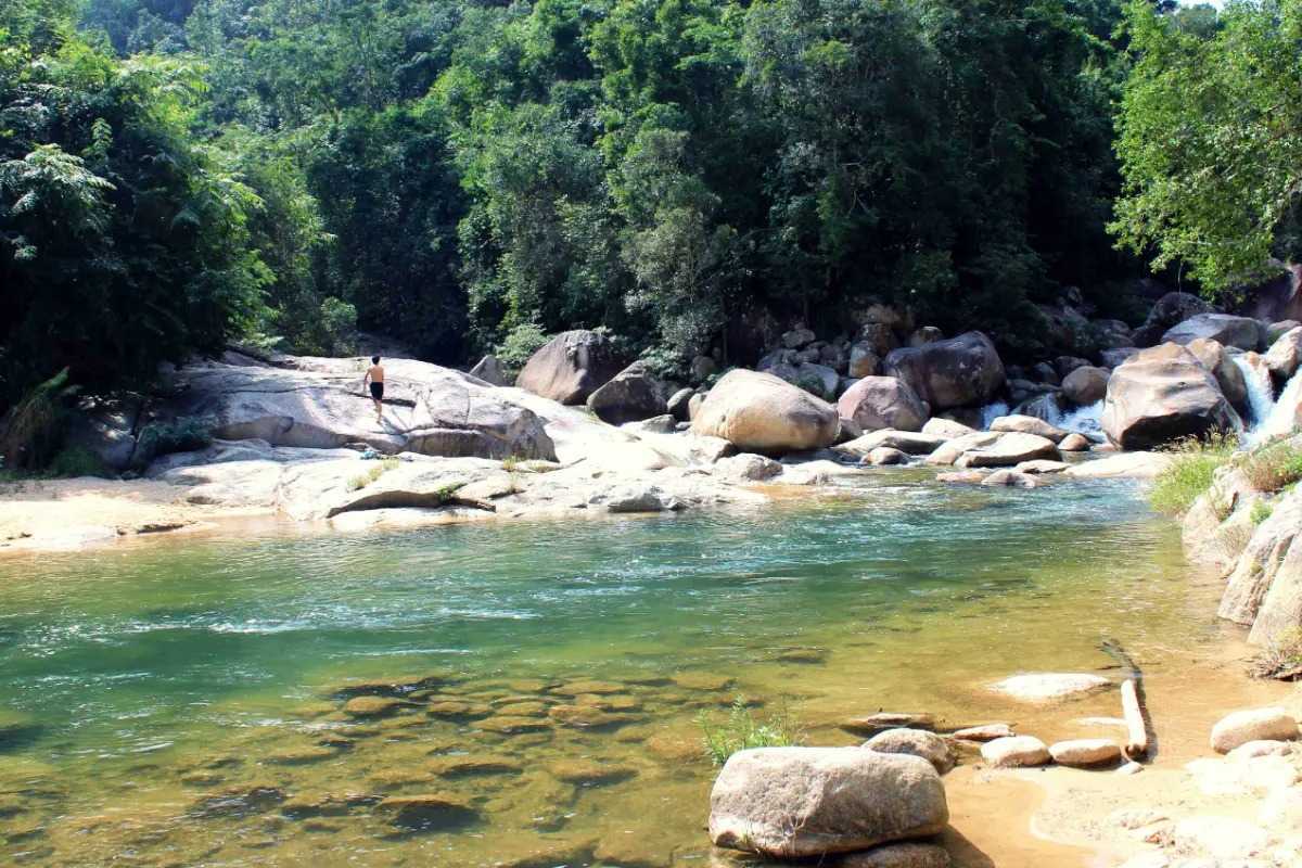 Calm forest stream at Waterland Thach Lam Still section of the stream surrounded by boulders and trees within Waterland Thach Lam.