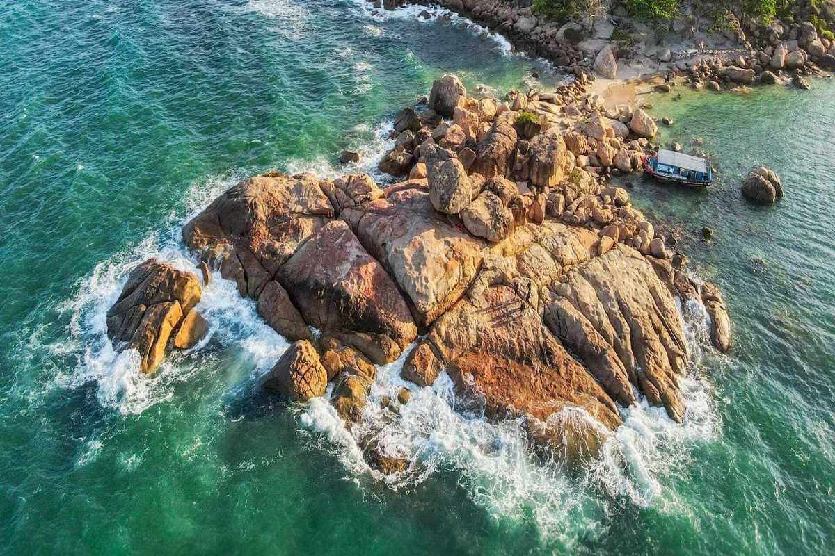 Ocean waves crashing against granite boulders at Hon Chong Promontory Nha Trang