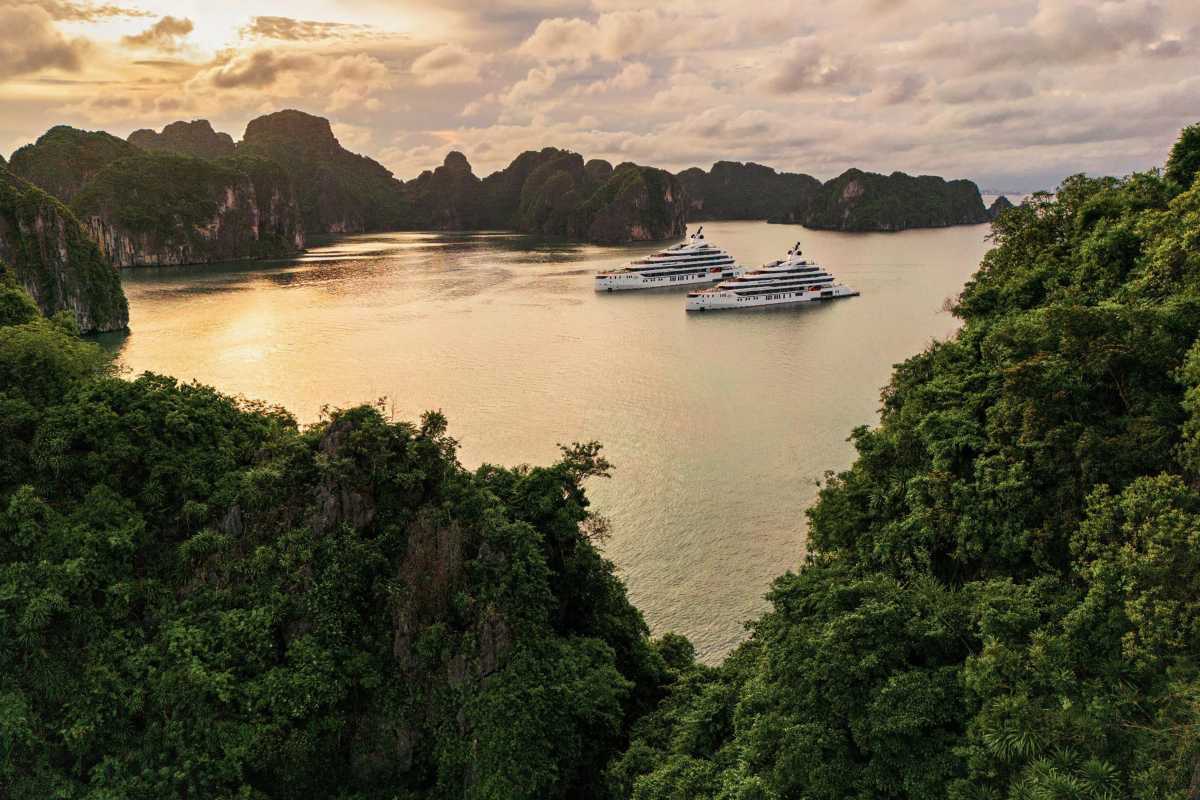 Aerial panorama showing the lush green islands and boats navigating the waters of Xep Islet Halong Bay.