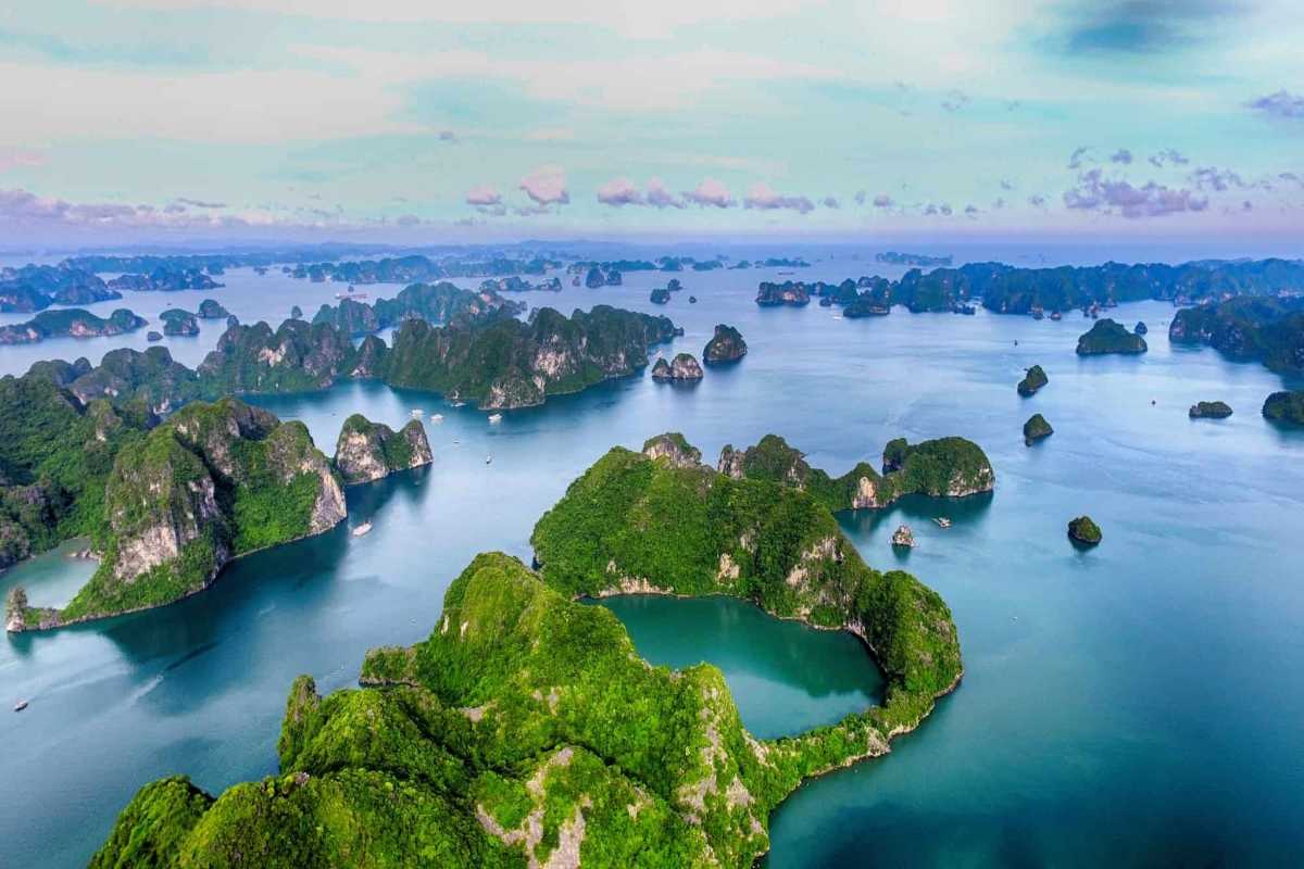 Multiple boats anchored near green islands in the calm waters of Xep Islet Halong Bay, highlighting peaceful surroundings.