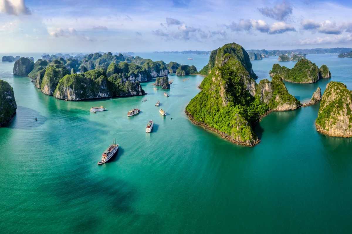 Kayakers enjoying a peaceful paddle around limestone islands in the clear waters of Xep Islet Halong Bay.