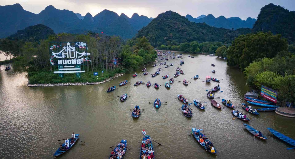 Yen Stream During Perfume Pagoda Festival – A Cultural Pilgrimage Boats on Yen Stream during Perfume Pagoda Festival with pilgrims making their way through lush mountains to the sacred pagoda.