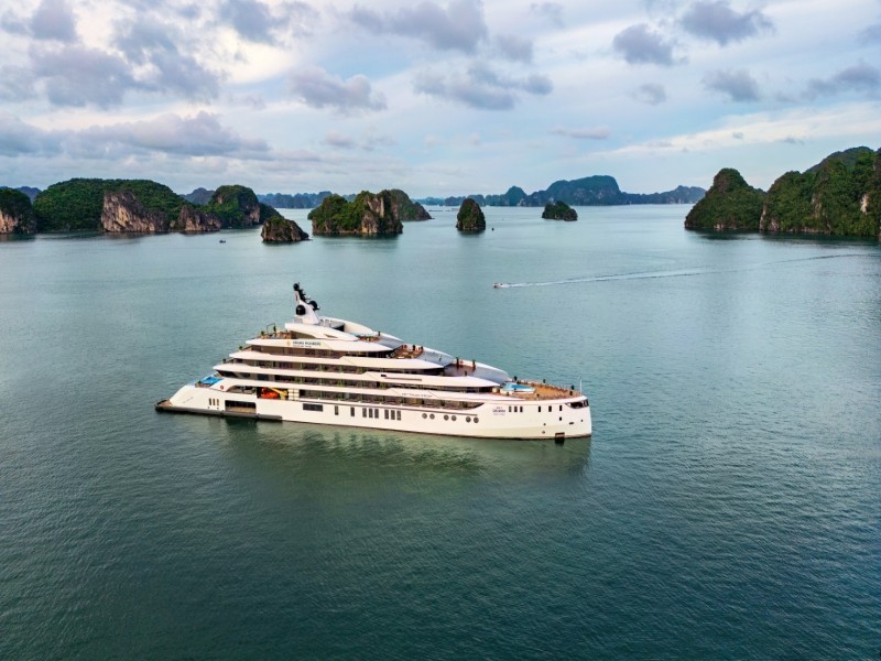 Grand Pioneers Cruise resting calmly in the waters of Ha Long Bay surrounded by green islets.