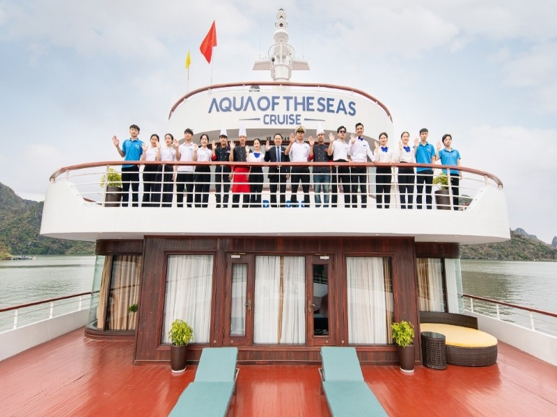 The crew of Aqua of the Seas waving on the upper deck