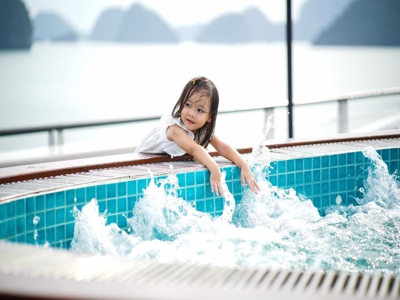 Bé gái đang vui chơi tại bể sục với cảnh đẹp Vịnh Hạ Long trên Du thuyền Aspira