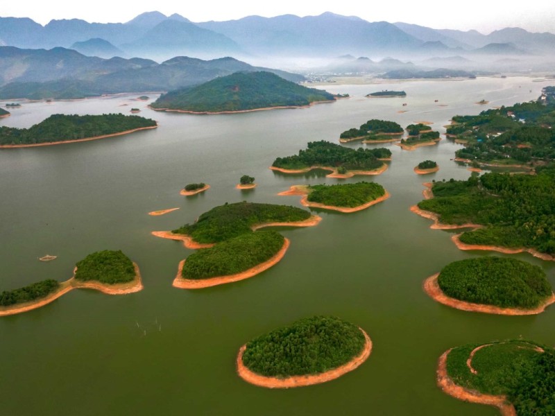 Aerial View of Nui Coc Lake and Islets Aerial view of Nui Coc Lake with multiple islets and mountains in the background