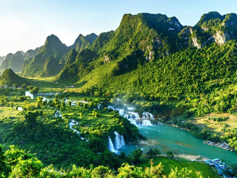 Ban Gioc Waterfall Sunrise View Ban Gioc Waterfall with the golden hues of sunrise lighting up the landscape in Cao Bang.