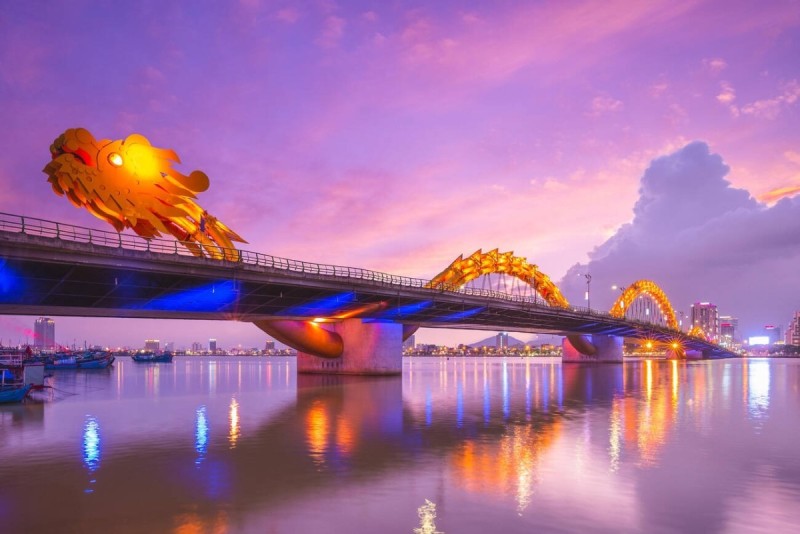 Dragon Bridge at Sunset - Da Nang Dragon Bridge in Da Nang, Vietnam during sunset, beautifully illuminated with vibrant colors reflecting in the river.