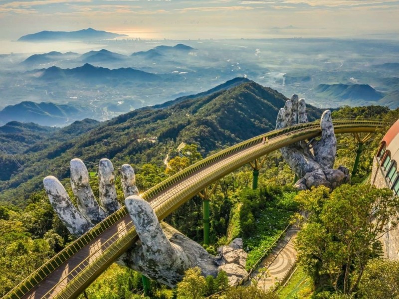Golden Bridge in Ba Na Hills - Da Nang The Golden Bridge held by two giant stone hands at Ba Na Hills, Da Nang, Vietnam with a scenic mountain backdrop.