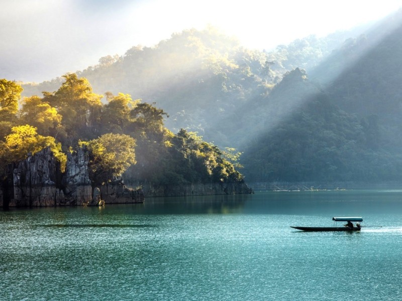 Na Hang Lake in Tuyen Quang - Serene Beauty at Sunrise Na Hang Lake in Tuyen Quang with tranquil water and misty sunrise, surrounded by lush mountains.