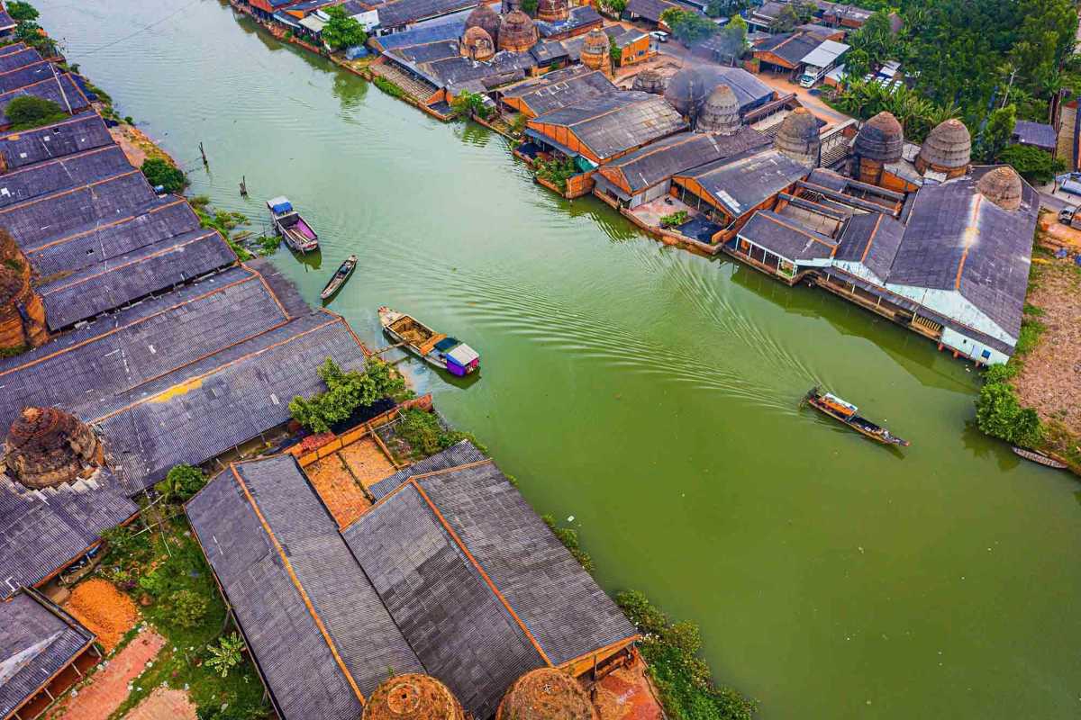 Aerial view of Vinh Long canal with boats Boats navigating narrow canals bordered by traditional houses and greenery in Vinh Long Mekong Delta