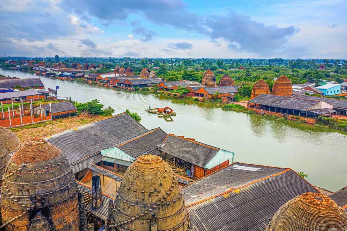 Vinh Long Mekong Delta riverside village aerial Aerial shot of Vinh Long riverside village with clay dome-shaped houses clustered by waterways
