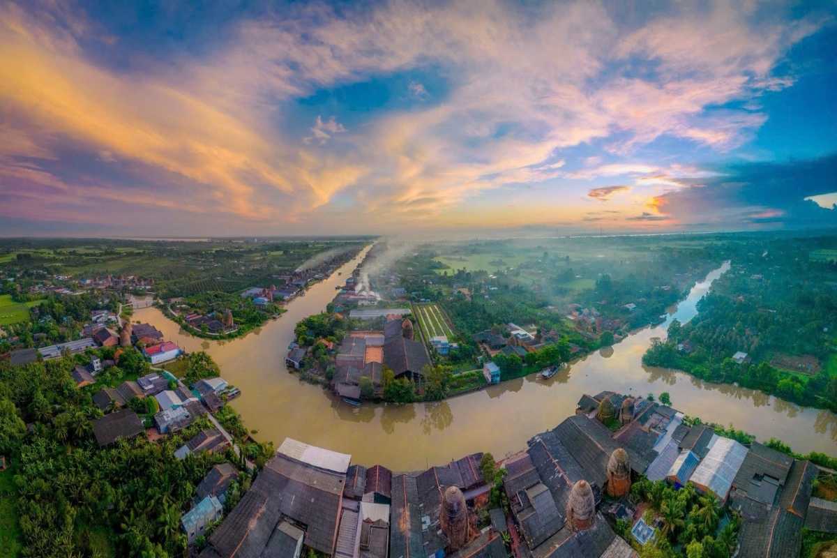 Vinh Long Mekong Delta sunrise aerial view Aerial sunrise view of Vinh Long Mekong Delta showing waterways, traditional houses, and morning mist