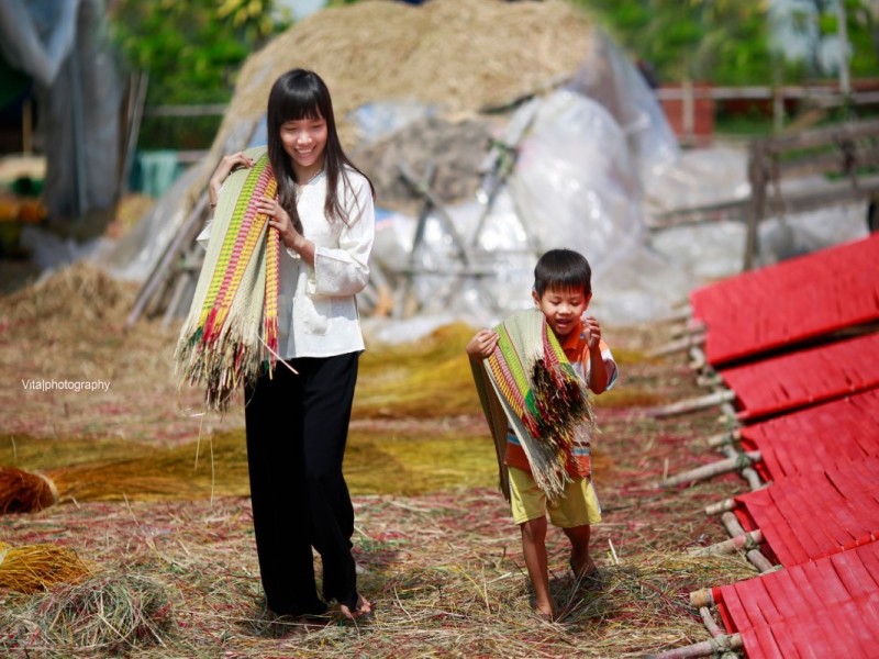 Weaving Craft at Dinh Yen Village Close-up of hands weaving mats in Dinh Yen Village, highlighting the skilled craftsmanship in Dong Thap.