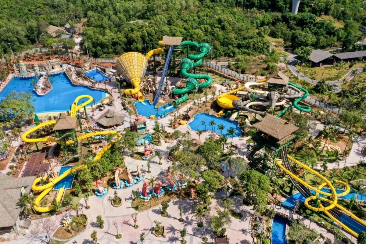 Drone view of colorful slides, pools, and tropical setting of Aquatopia Water Park on Thom Island